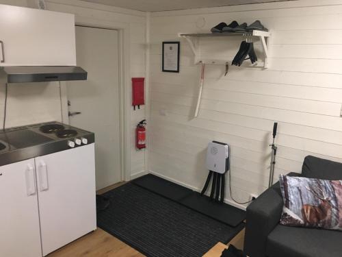a kitchen with a stove and a couch in a room at Camp Caroli Wooden Cabins in Jukkasjärvi