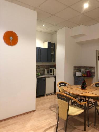 a kitchen with a table and a clock on a wall at Munich Apartment Harras (Souterrain) in Munich