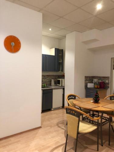 een keuken met een tafel en een klok aan een muur bij Munich Apartment Harras (Souterrain) in München