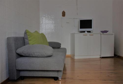 a living room with a chair and a television at Da Rinota in Alta Val di Non in Malosco