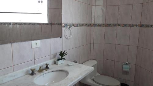 a bathroom with a sink and a toilet at Pousada Elegance Beira Mar in Itanhaém