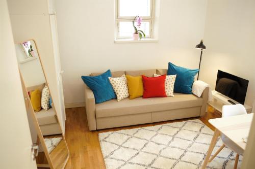 ヘルシンキにあるStay Here Apartment Liisaのリビングルーム(カラフルな枕とソファ付)