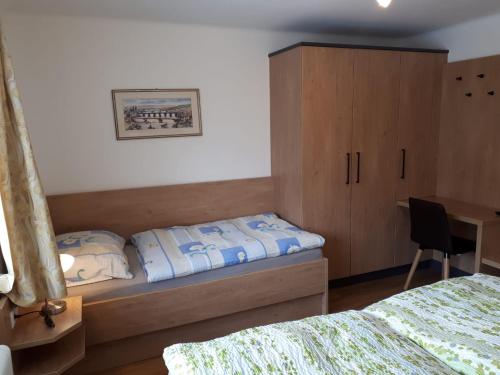 a bedroom with a bed and a cabinet and a desk at Ferienhaus Reinfrank in Sankt Michael im Lungau