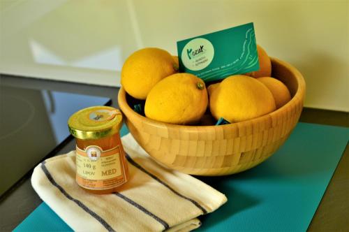 a bowl of lemons on a table with a jar of honey at Sleeping with the bees Kozjak in Kobarid