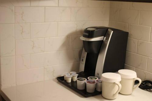 a coffee maker and coffee cups on a counter at Norwalk Inn & Conference Center in Norwalk