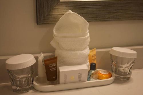 a pile of towels on a counter with two cups at Norwalk Inn & Conference Center in Norwalk