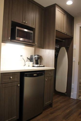 a kitchen with wooden cabinets and a microwave at Norwalk Inn & Conference Center in Norwalk