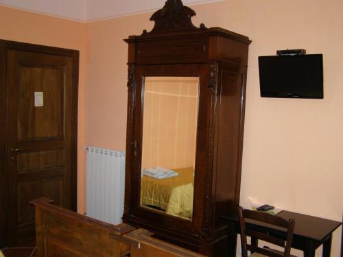 a large wooden cabinet with a mirror in a room at B&B Le Grazie in Piaggine
