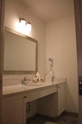 a bathroom with a sink and a mirror at Norwalk Inn & Conference Center in Norwalk