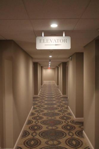 a long hallway with a tile floor in a building at Norwalk Inn & Conference Center in Norwalk