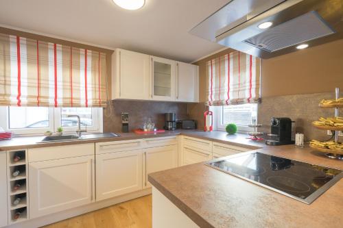 a kitchen with white cabinets and granite counter tops at Chalet Alpin in Oberstdorf