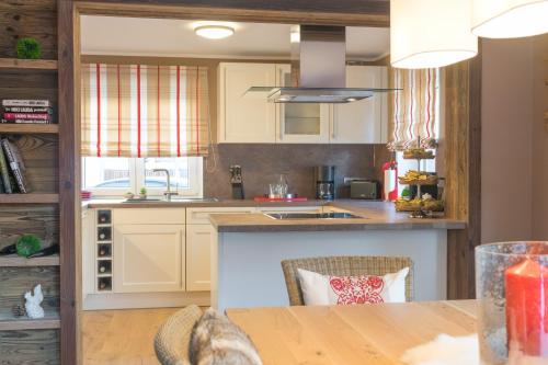 a kitchen with white cabinets and a wooden table at Chalet Alpin in Oberstdorf