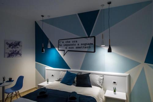 a bedroom with a blue and white striped wall at B&B Luna per te in Benevento