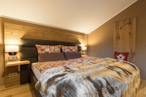 a bedroom with a large bed with a wooden headboard at Chalet Alpin in Oberstdorf