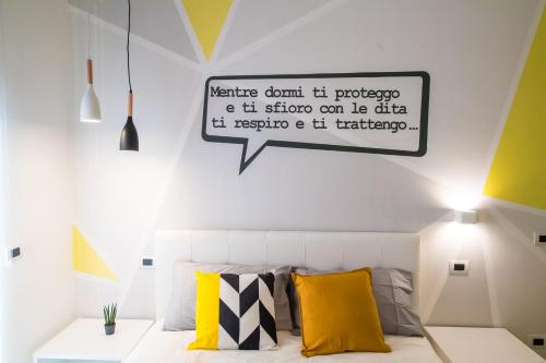 a bedroom with a bed with a sign on the wall at B&B Luna per te in Benevento