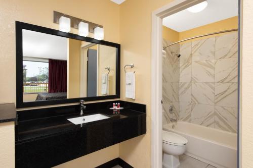 a bathroom with a sink and a tub and a toilet at Days Inn by Wyndham Salem, Illinois in Salem