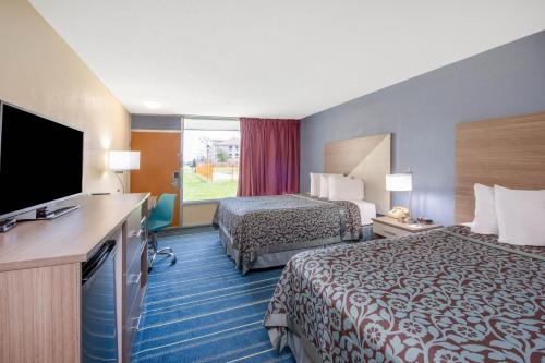 a hotel room with two beds and a flat screen tv at Days Inn by Wyndham Salem, Illinois in Salem