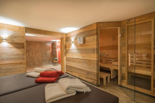 a spa room with wooden walls and two beds at Chalet Alpin in Oberstdorf