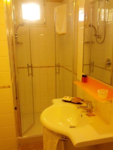 a bathroom with a sink and a glass shower at JR Resort Logos Forte dei Marmi in Forte dei Marmi
