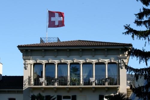 a building with a flag on top of it at Continental Parkhotel in Lugano