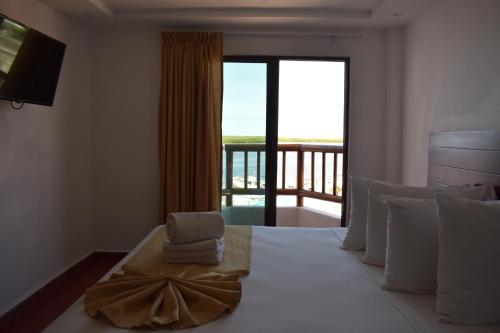 a bedroom with a bed with a view of a balcony at Hotel Rio Lagartos in Río Lagartos