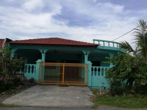 une maison bleue avec une porte jaune devant elle dans l'établissement Teratak Port Dickson Homestay Mus Only, à Port Dickson
