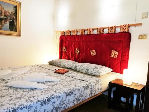 una camera con letto con testiera rossa di Apart 1531 a Venezia