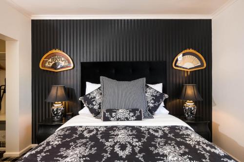 a bedroom with a black and white bed with two lamps at Battery Point Boutique Accommodation in Hobart