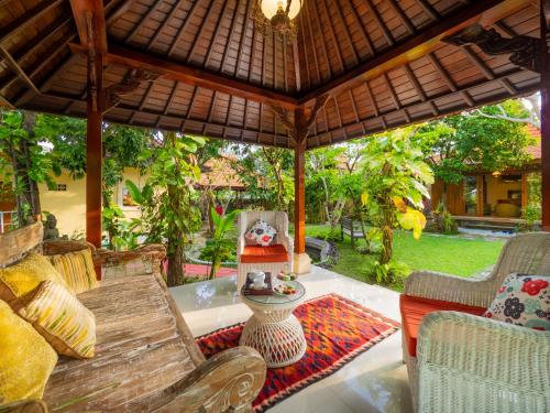 an outdoor patio with a table and chairs at Tiis Garden Puri Villas in Gianyar