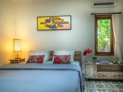 a bedroom with a bed and a window at Tiis Garden Puri Villas in Gianyar