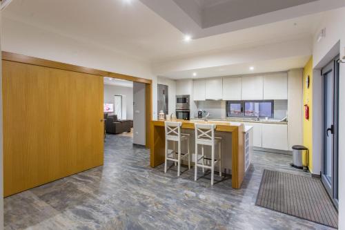 a kitchen with a counter and two stools at Feel Discovery Douro LAS House in Peso da Régua