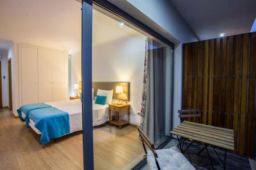 een slaapkamer met een bed en een bank in een kamer bij Feel Discovery Douro LAS House in Peso da Régua