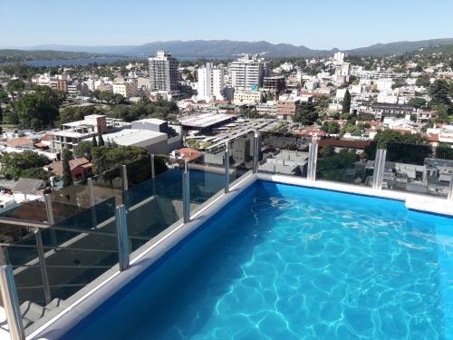 una piscina en la azotea de un edificio en Dpto Teatro Melos microcentro pileta y cochera en Villa Carlos Paz