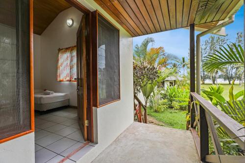 an open door to a house with a porch at Beachfront Resort in Luganville