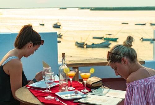 two women sitting at a table with wine glasses at Hotel Rio Lagartos in Río Lagartos