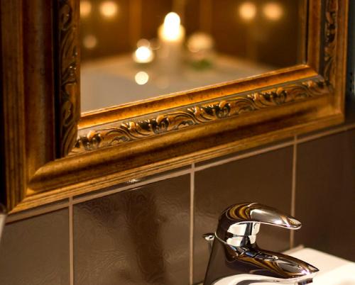 a bathroom sink with a mirror and a faucet at Hotel Kostelski Buk in Bihać