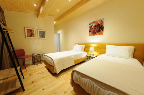 a hotel room with two beds and a chair at Naya-Downtown Guesthouse in Porto