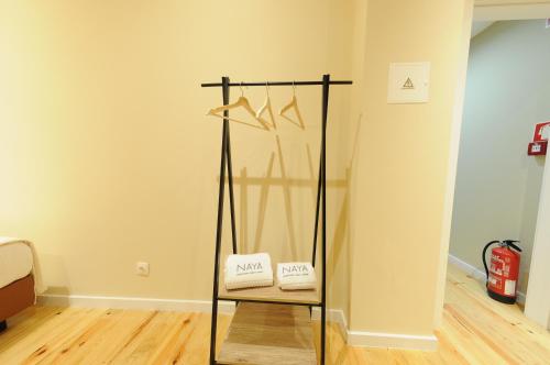a room with a chair and a rack with clothes at Naya-Downtown Guesthouse in Porto