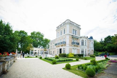 une grande maison blanche avec un jardin en face de celle-ci dans l'établissement Chateau du Clos de la Ribaudiere - Teritoria, à Chasseneuil-du-Poitou