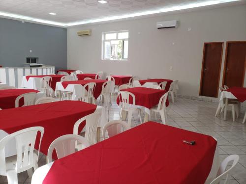 a room with red and white tables and chairs at Excelsior Hotel in Caxias das Aldeias Altas