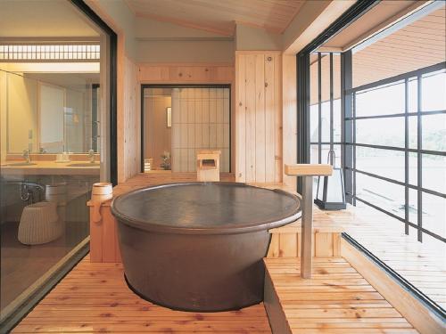 a large bath tub in a bathroom with a large window at Yunokawa Kanko Hotel Shoen in Hakodate