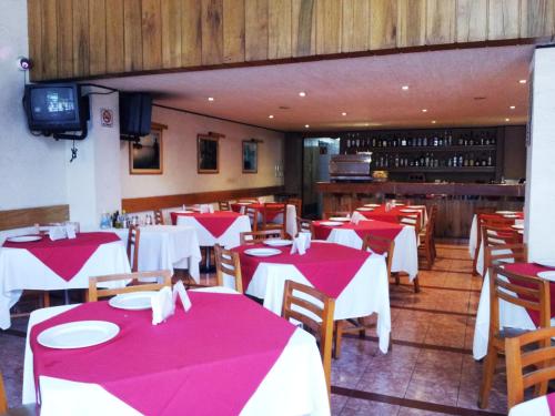 un restaurante con mesas y sillas rojas y blancas en Hotel El Salvador, en Ciudad de México