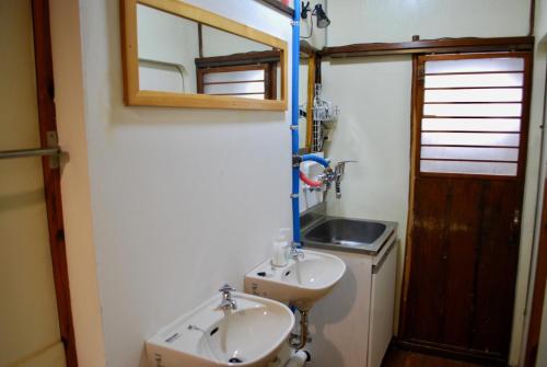 een badkamer met een wastafel en een spiegel bij Nomad Hostel Classic in Tokyo