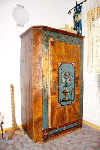 an old wooden cabinet with a painting on the door at Haus Lisa in Fuschl am See