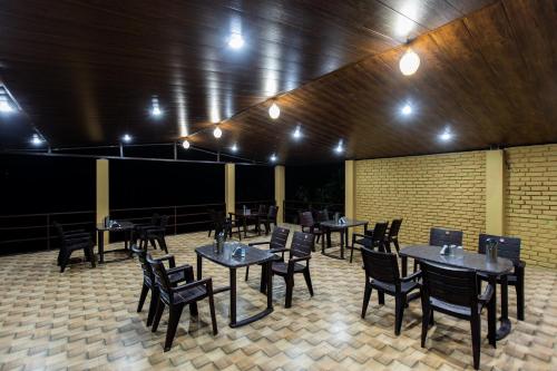 a dining room with tables and chairs and lights at Camp Bagheera in Rishīkesh