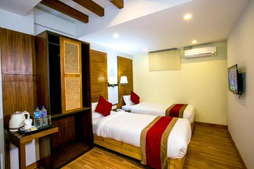 a hotel room with two beds and a television at Beautiful Kathmandu Hotel in Kathmandu