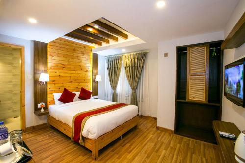 a bedroom with a bed and a television in a room at Beautiful Kathmandu Hotel in Kathmandu