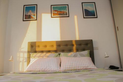 ein Schlafzimmer mit einem Bett mit zwei Kissen und Bildern an der Wand in der Unterkunft Unit 1109 Cityscape Residences in Bacolod City