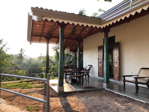 a porch of a house with a table and chairs at Horizon Villa in Unawatuna