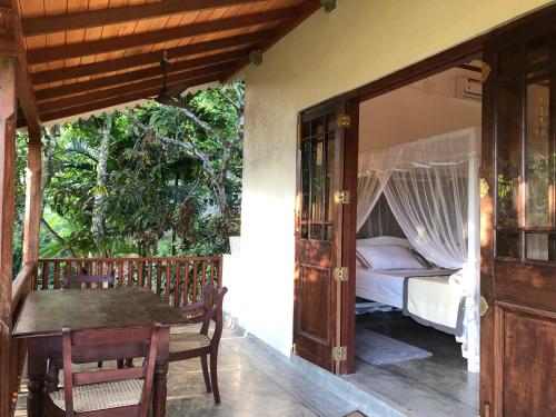 a bedroom with a bed and a table and a table and chairs at Horizon Villa in Unawatuna